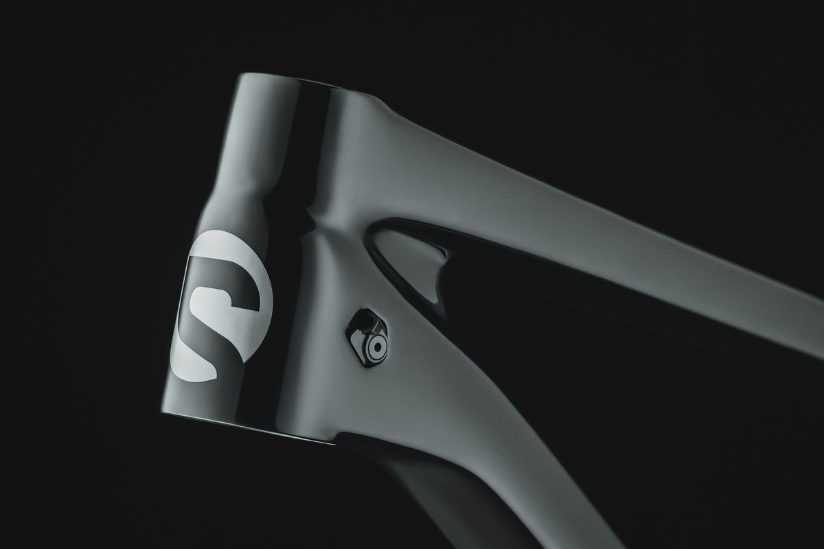 Mayhem 140 in Liquid Black — Head tube and Spot logo, looking along the top tube