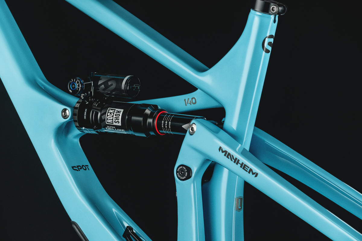 Mayhem 140 in Alpine Blue — Rear shock and rocker link seen through the front triangle