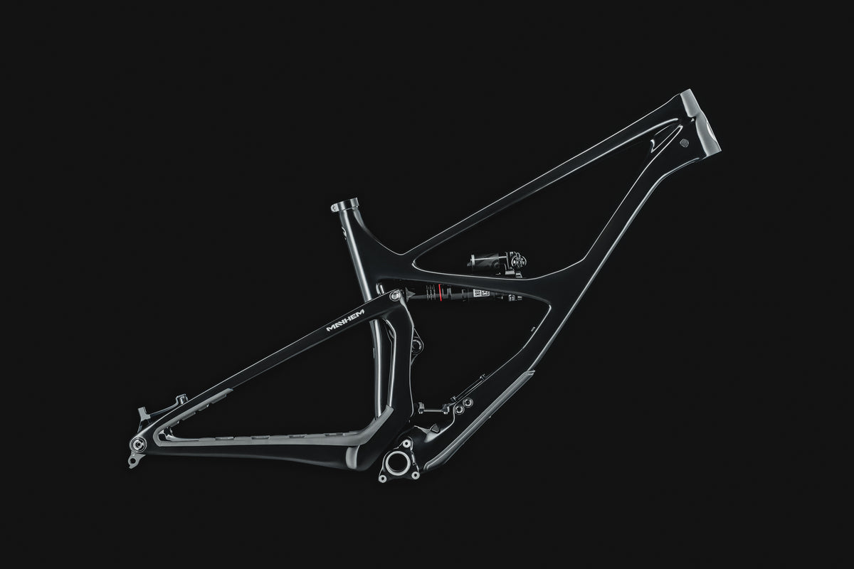 Mayhem 140 in Liquid Black — Frame in silhouette, lit along the top tube and seatstays