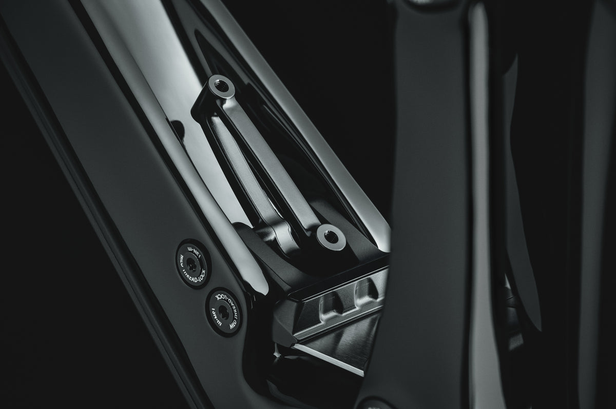Mayhem 140 in Liquid Black — Living Link leaf spring and pivot hardware; showcasing bottle mount